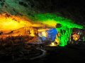 Colorful illuminated limestone formations inside a cave.