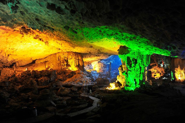 Colorful illuminated limestone formations inside a cave.