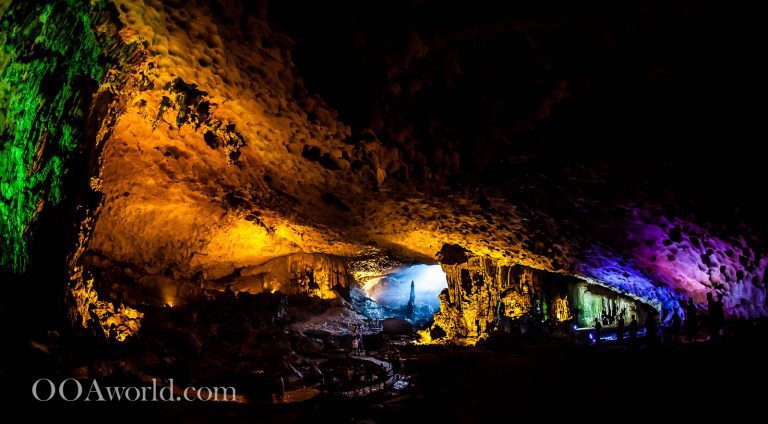 Colorful illuminated cave interior with stalactites.